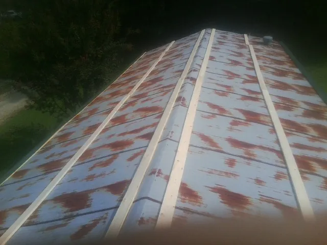 Rusted metal roof panels with new wood purlins before replacement — Storm Damage Roof Repair in Eustis by Roofing Brothers